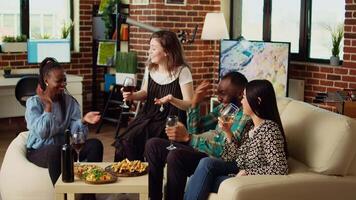 Woman telling interesting story to happy apartment party guests during weekend gathering, gossiping about friend. Friends listening to funny tale from host while drinking wine and eating snacks video