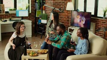Diverse friends throwing surprise birthday party for asian woman, giving her thoughtful gift in living room. Cheerful group of people celebrating host anniversary, gifting neatly packaged present video
