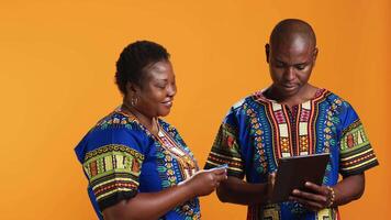 Smiling man purchasing clothes on internet with credit card, filling in transaction details for online shopping checkout. African american people enjoying discount season and buying items. video