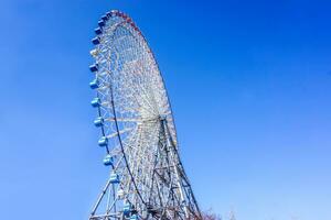 Closeup Tempozan Giant Ferris Wheel on bright blue sky background. photo