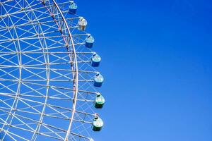 Closeup and crop Tempozan Giant Ferris Wheel on bright blue sky background with space for texts. photo