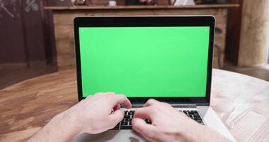 Male hands typing on a computer with a green screen on a vintage table video