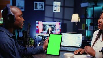 Isolated screen tablet in front of show host recording podcast, enjoying nice conversation with happy guest. Chroma key device in professional studio used for podcasting live session with woman video