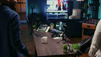 African american man and woman arriving together in apartment studio, ready to start recording podcast. Host inviting guest in living room used as broadcasting space to share stories video