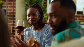 African american woman at apartment party watching man share interesting story, having crush on him. Guest at home gathering in love with charming BIPOC host captivating friends with tale video