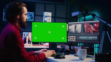 Videographer using professional software on mockup PC to create visual effects for video projects. Expert using post production techniques to edit raw clips footage on green screen computer