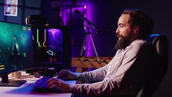 Man in neon lit apartment having fun and laughing while playing entertaining videogame, flying spaceship through galaxy. Pro gamer using desktop PC with powerful graphics to enjoy science fiction game video