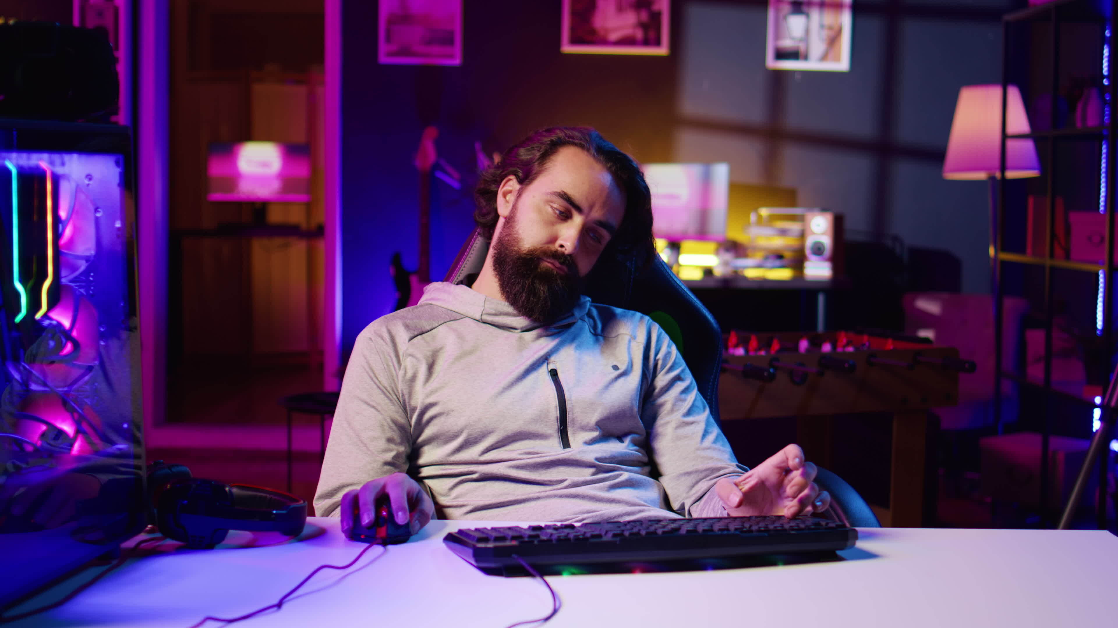 Man obsessed with playing videogames all day falling asleep at computer