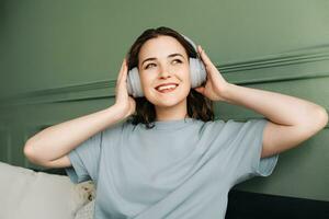 Chill and Melodies. Happy Young Woman Immersed in Weekend Music. Soothing Sounds. Woman in Wireless Headphones Enjoying Weekend Beats photo