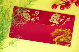 Top view of Chinese New Year red packet with golden dragon and cherry. Chinese New Year concept photo