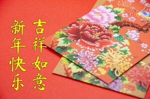 Close up of colorful envelope on red cover background with Chinese New Year wishes photo