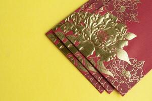 Top view of golden red envelopes on yellow cover with customizable space for text photo