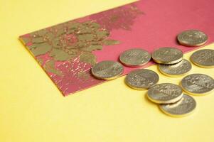 Chinese New Year red packets and golden coins on yellow cover. Customizable space for text. photo