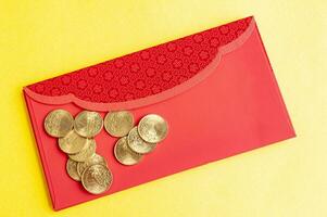 Top view of red envelopes with golden coins on yellow cover with customizable space for text. photo