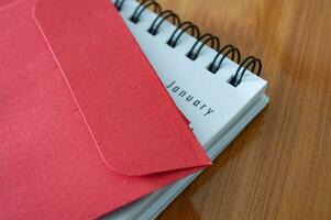 Close up view of Chinese New Year red packets with January table calendar photo