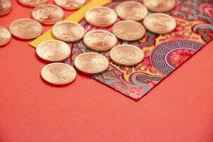 Close up of colorful envelope and golden coins on red cover background photo