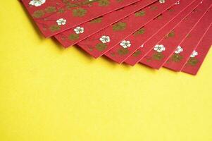 Chinese New Year red packets on yellow cover background with customizable space for text. photo