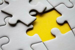 Close up view of missing jigsaw puzzle on yellow background. Copy space. photo
