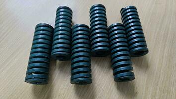 Metal die spring coils are used in industrial machines. photo