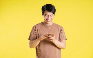 retrato de asiático hombre posando en amarillo antecedentes foto