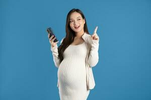 Portrait of pregnant asian woman, isolated on blue background photo