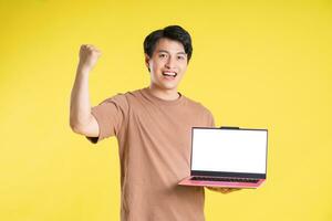 Portrait of asian man posing on yellow background photo