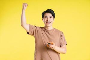 Portrait of asian man posing on yellow background photo