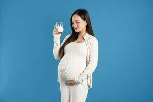 Portrait of pregnant asian woman, isolated on blue background photo