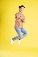 Portrait of asian man posing on yellow background photo