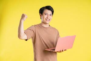 Portrait of asian man posing on yellow background photo