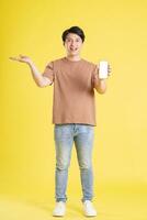 Portrait of asian man posing on yellow background photo