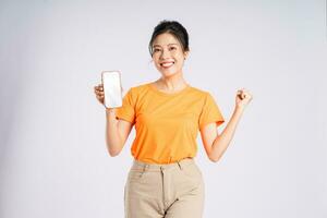 Portrait of cheerful happy Asian woman posing on white background photo