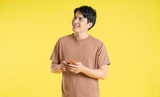 Portrait of asian man posing on yellow background photo
