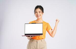 retrato de alegre contento asiático mujer posando en blanco antecedentes foto