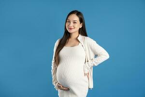 Portrait of pregnant asian woman, isolated on blue background photo