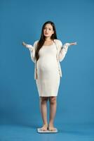 Portrait of pregnant asian woman, isolated on blue background photo