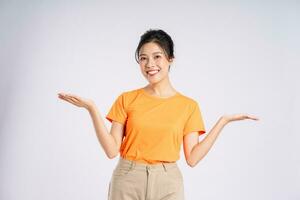 Portrait of cheerful happy Asian woman posing on white background photo