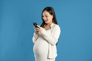 Portrait of pregnant asian woman, isolated on blue background photo