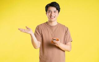 Portrait of asian man posing on yellow background photo
