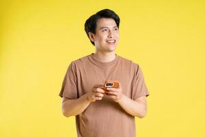 Portrait of asian man posing on yellow background photo