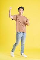 Portrait of asian man posing on yellow background photo