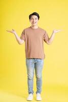 Portrait of asian man posing on yellow background photo