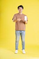 Portrait of asian man posing on yellow background photo