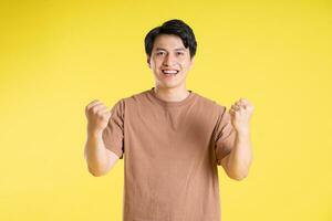 Portrait of asian man posing on yellow background photo