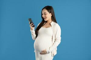 Portrait of pregnant asian woman, isolated on blue background photo