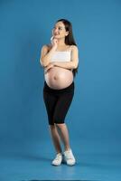 Portrait of pregnant asian woman, isolated on blue background photo