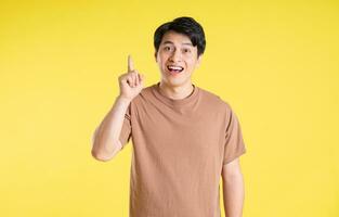 Portrait of asian man posing on yellow background photo