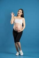 Portrait of pregnant asian woman, isolated on blue background photo