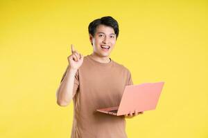 Portrait of asian man posing on yellow background photo