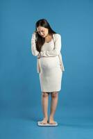 Portrait of pregnant asian woman, isolated on blue background photo